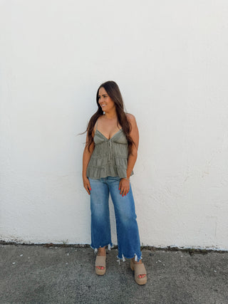 Woman modeling a sage top and jeans