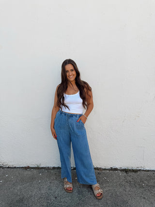 Woman modeling a white tank and blue jeans