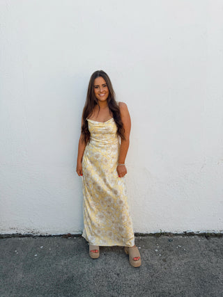 Woman modeling a yellow floral satin dress