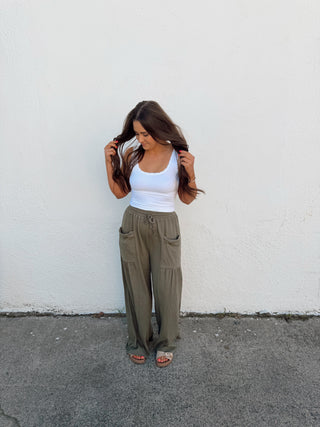 Woman modeling an olive green pant and white tank