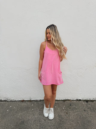 Woman modeling a pink romper dress