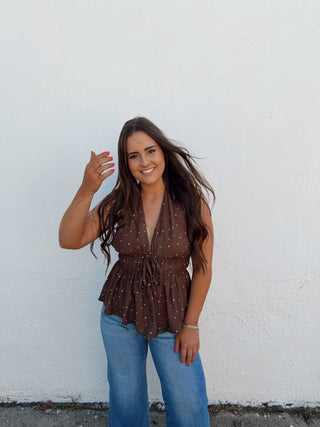 Woman modeling a chocolate and white polka dot top