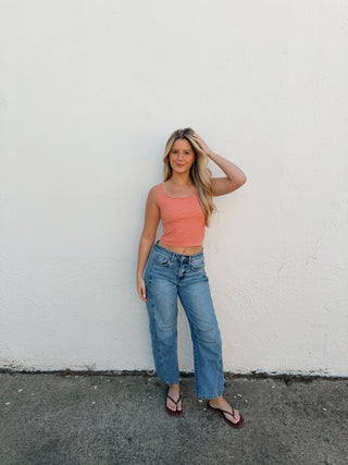 Woman modeling a coral tank and jeans