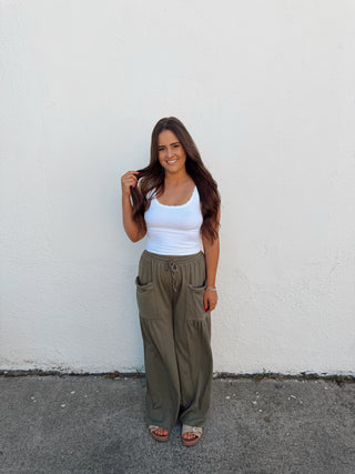 Woman modeling an olive green pant and white tank
