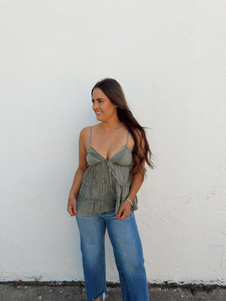 Woman modeling a sage top and jeans