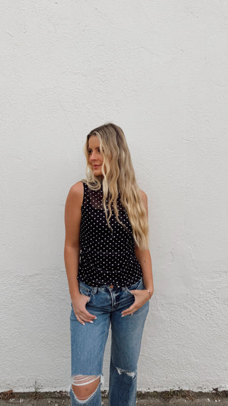 Woman modeling a black polka dot mesh tank