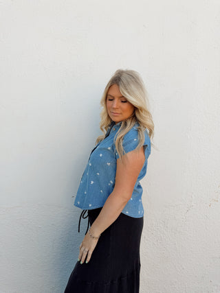 Woman modeling a denim floral top and black pants