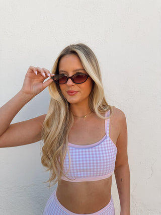 Woman modeling a pink gingham activewear set