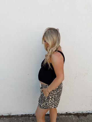 Woman modeling leopard shorts and a black tank