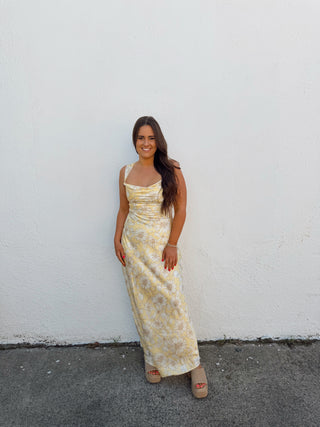 Woman modeling a yellow floral satin dress