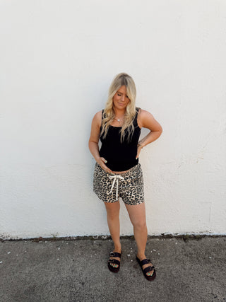 Woman modeling leopard shorts and a black tank