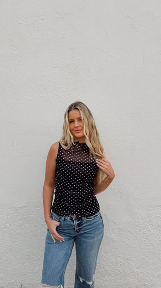 Woman modeling a black polka dot mesh tank
