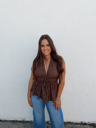 Woman modeling a chocolate and white polka dot top