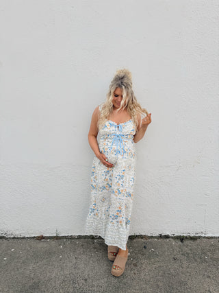 Woman modeling an ivory floral dress