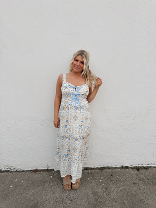 Woman modeling an ivory floral dress