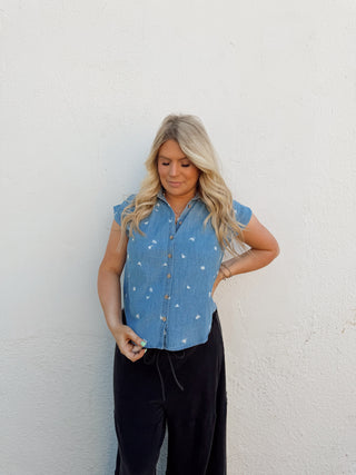 Woman modeling a denim floral top and black pants