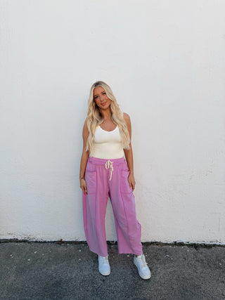 Person modeling pink barrel sweatpants with a white tank