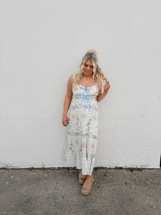 Woman modeling an ivory floral dress