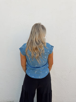 Woman modeling a denim floral top and black pants