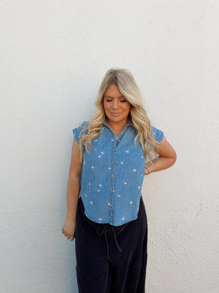 Woman modeling a denim floral top and black pants