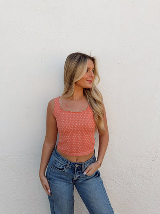 Woman modeling a coral tank and jeans