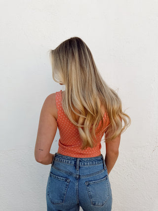 Woman modeling a coral tank and jeans