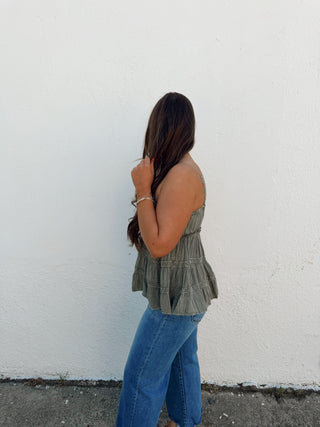 Woman modeling a sage top and jeans