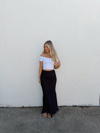 Person standing on a white sidewalk next to a gray curb