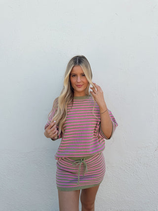 Girl wearing a pink/green striped knit set